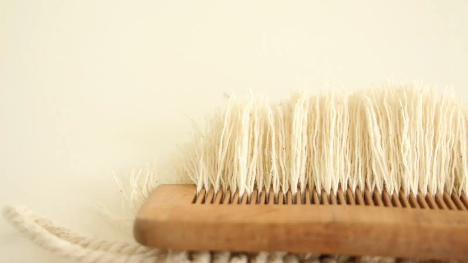A natural bristle wooden brush resting on soft cream fabric